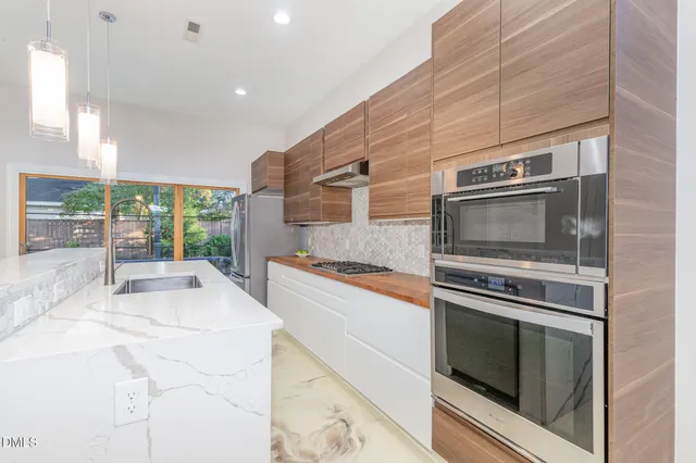 a kitchen with stainless steel appliances granite countertop a refrigerator and a sink