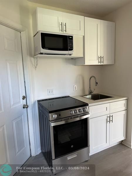 a kitchen with stainless steel appliances a stove a microwave and cabinets