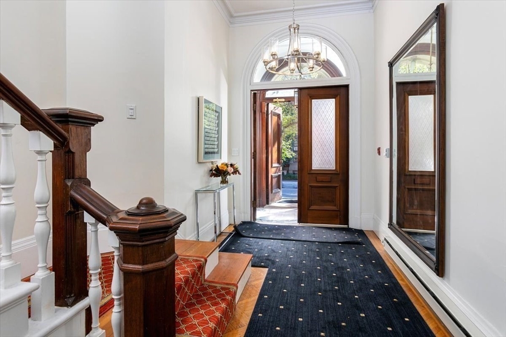 214 Beacon Street Boston, MA 02116 - Photo 3 of 21 a hallway with front door wooden floor and windows