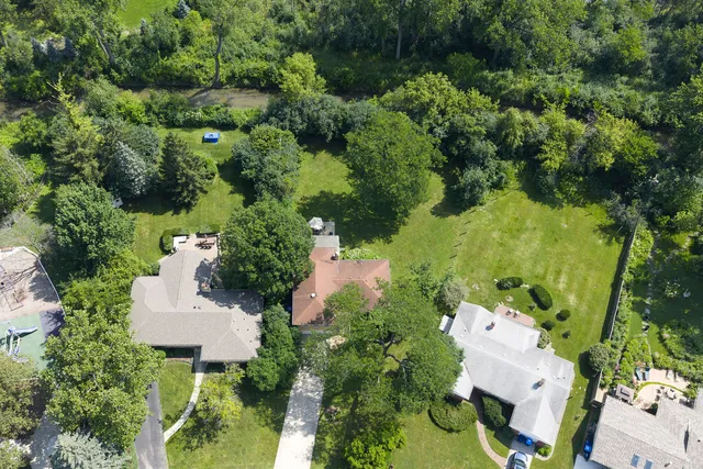 an aerial view of a house with a yard and lake view