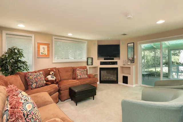 a living room with furniture a flat screen tv and a fireplace