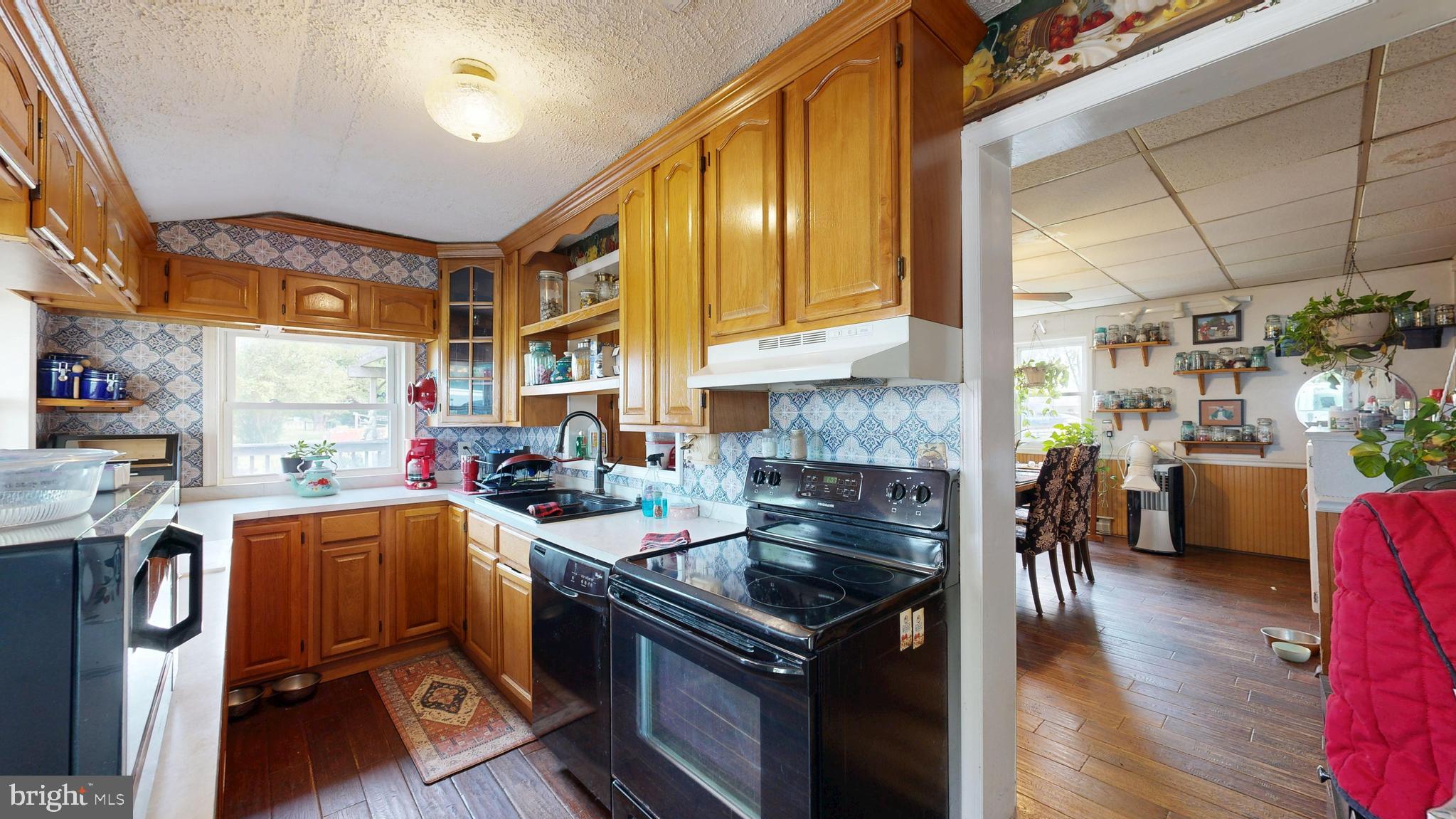 5403 Willow Grove Road Camden Wyoming, DE 19934 - Photo 14 of 44 a kitchen with stainless steel appliances granite countertop a stove top oven a sink dishwasher and cabinets with wooden floor