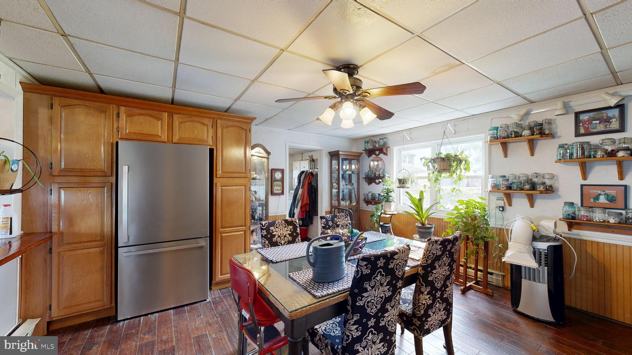 5403 Willow Grove Road Camden Wyoming, DE 19934 - Photo 15 of 44 a kitchen with stainless steel appliances a refrigerator a sink dishwasher a dining table and chairs with wooden floor