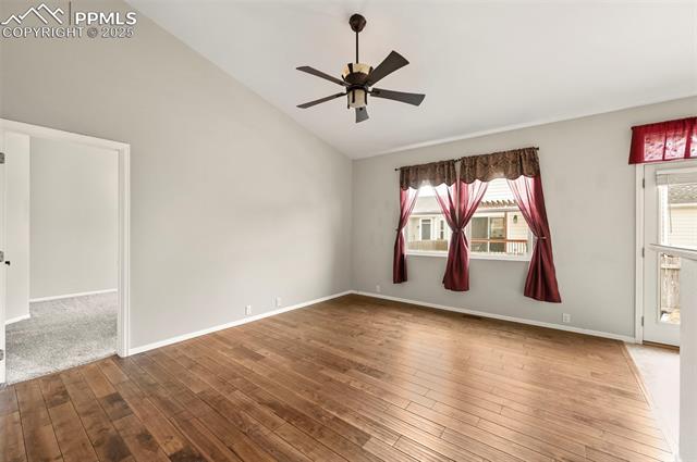 11927 Rodez Grove Peyton, CO 80831 - Photo 5 of 34 Spare room with a ceiling fan, lofted ceiling, wood-type flooring, and baseboards