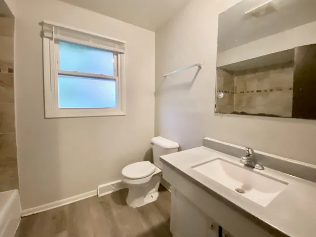 a bathroom with a granite countertop sink mirror and toilet