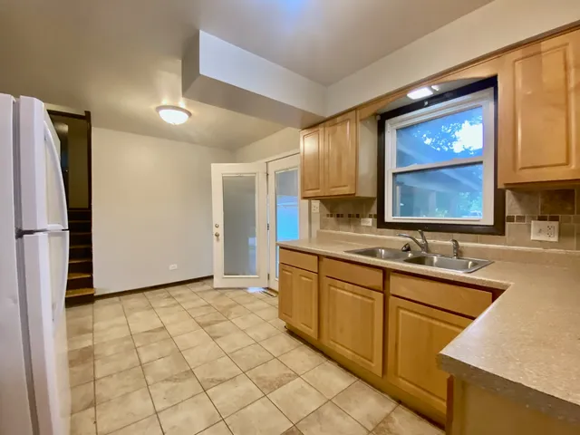 a kitchen with a sink a refrigerator and cabinets