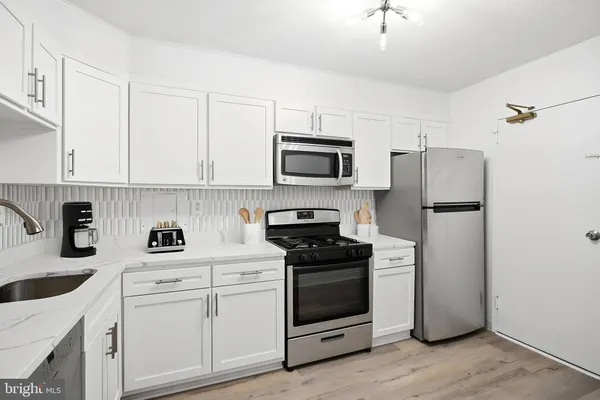 a kitchen with white cabinets and stainless steel appliances