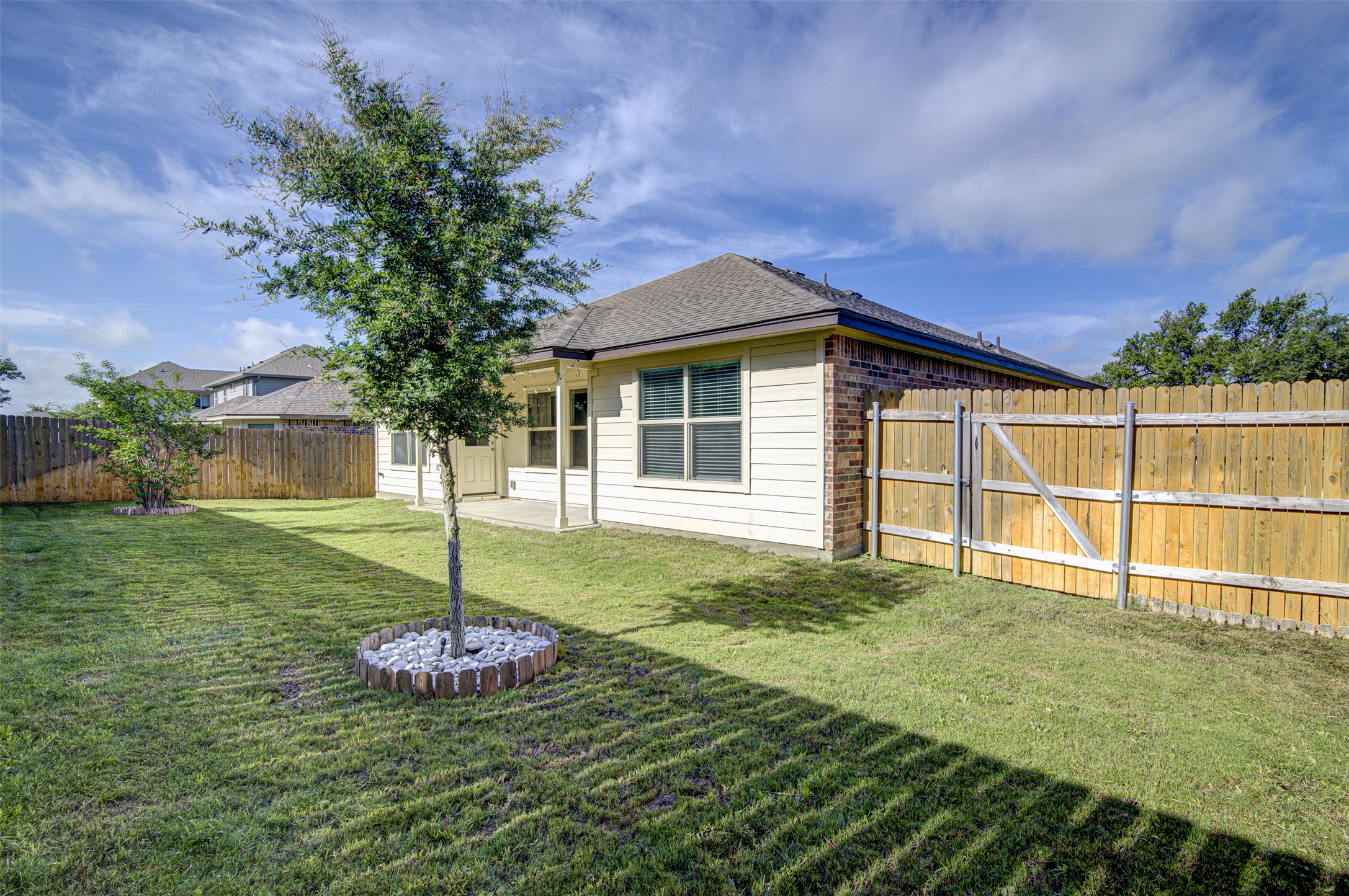316 Pepper Mill Loop Burnet, TX 78611 - Photo 23 of 27 A spacious backyard features a well-kept lawn, privacy fence, and a patio for outdoor enjoyment.