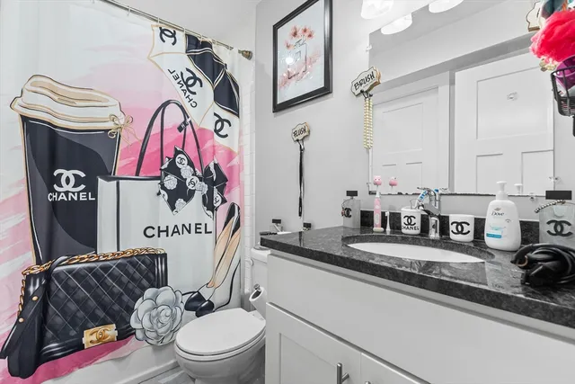 a bathroom with a granite countertop sink mirror vanity and toilet