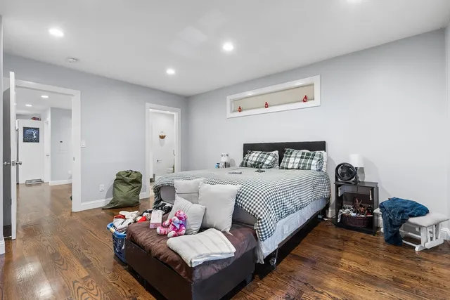 a spacious bedroom with a bed and wooden floor