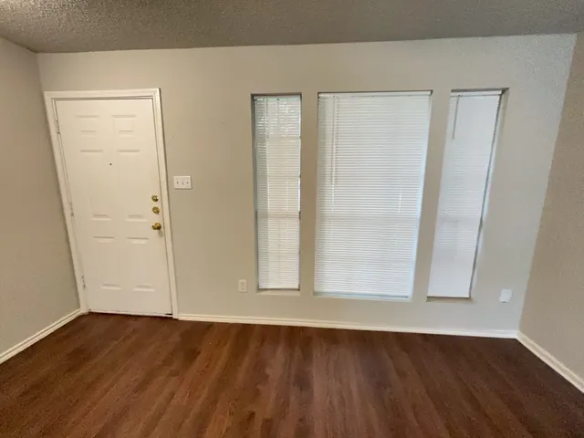 an empty room with wooden floor and door