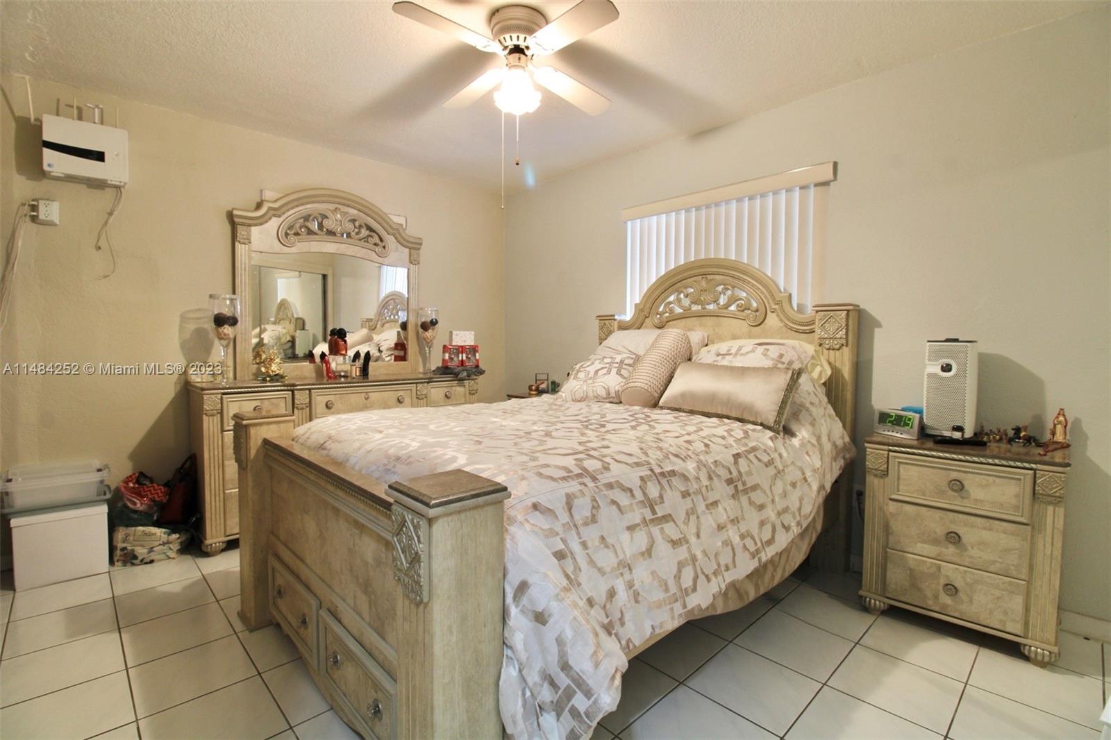 1085 West 23rd Street Hialeah, FL 33010 - Photo 11 of 32 a bedroom with a bed and a chandelier