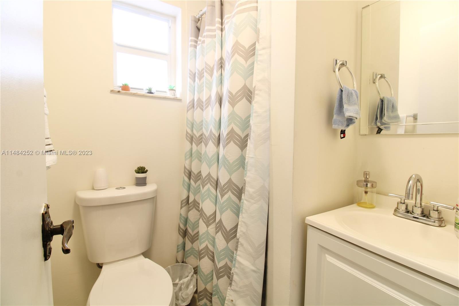 1085 West 23rd Street Hialeah, FL 33010 - Photo 15 of 32 a bathroom with a sink a toilet and a mirror