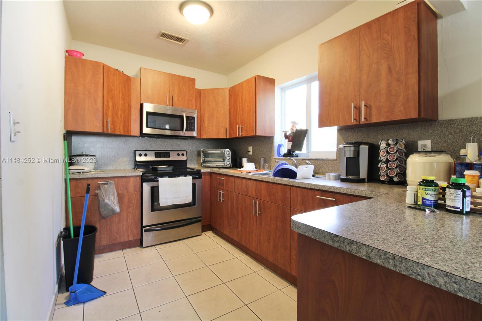1085 West 23rd Street Hialeah, FL 33010 - Photo 17 of 32 a kitchen with stainless steel appliances granite countertop a stove sink and cabinets