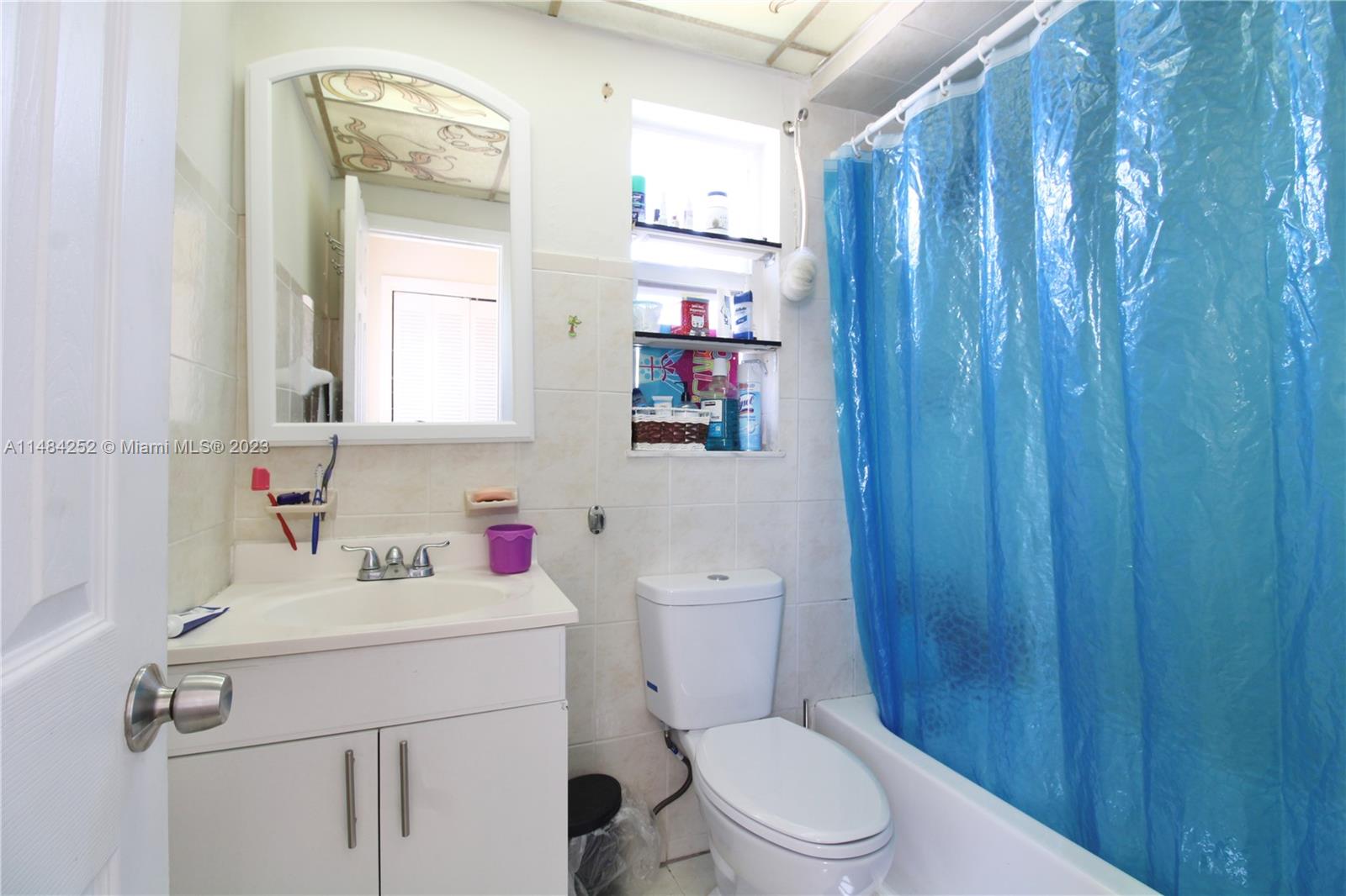 1085 West 23rd Street Hialeah, FL 33010 - Photo 19 of 32 a bathroom with a sink a toilet and shower curtain