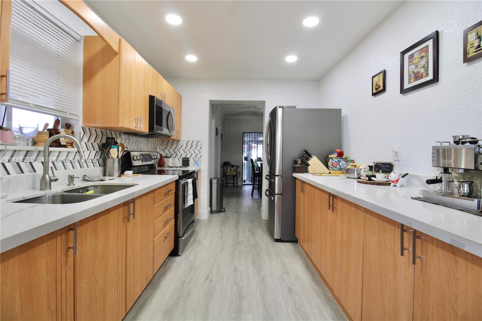 1085 West 23rd Street Hialeah, FL 33010 - Photo 7 of 32 a kitchen with stainless steel appliances granite countertop a sink stove and refrigerator