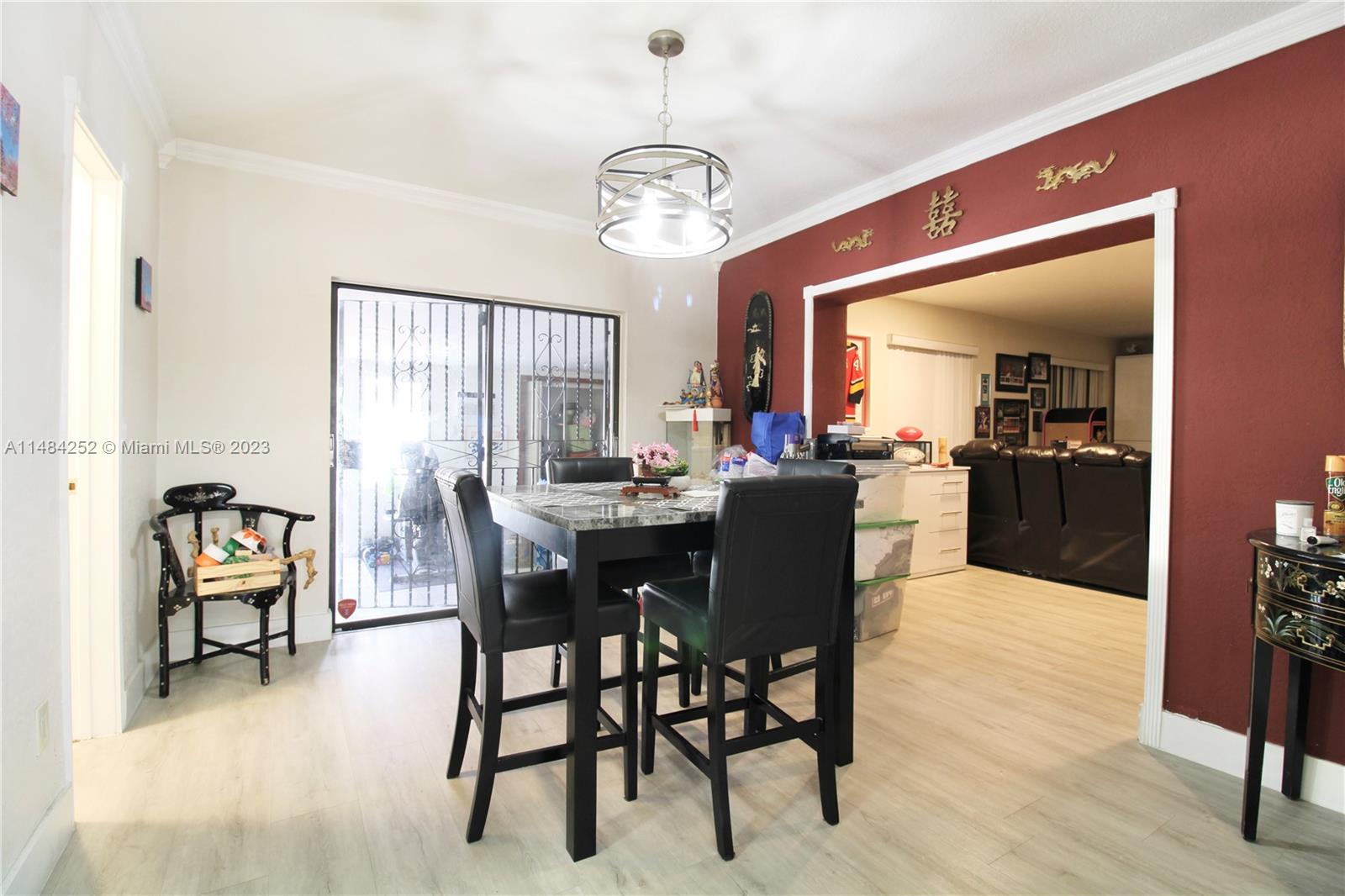 1085 West 23rd Street Hialeah, FL 33010 - Photo 9 of 32 a dining room with wooden floor a chandelier a wooden table and chairs