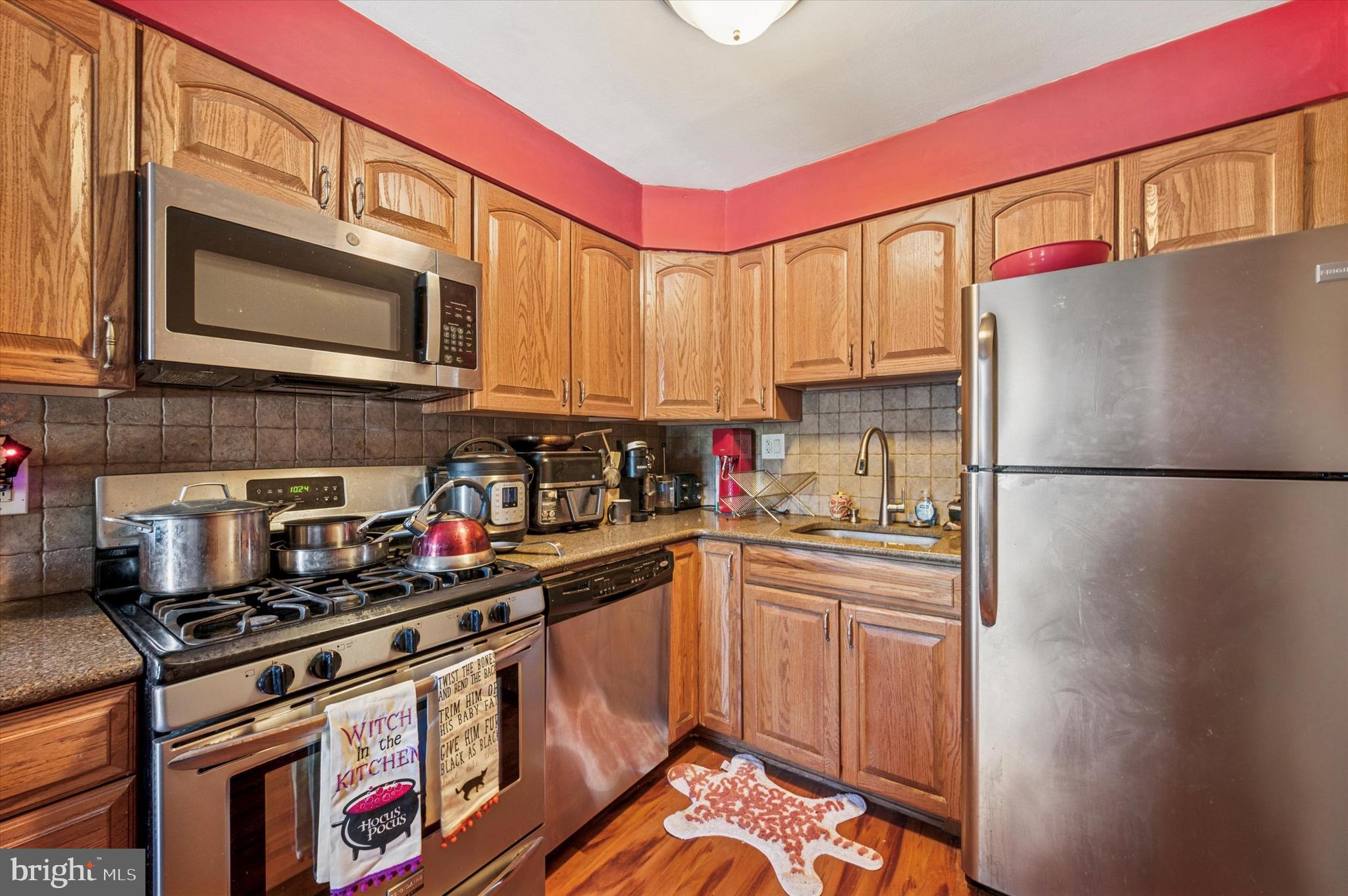 1600 Church Road, Unit A107 Wyncote, PA 19095 - Photo 5 of 15 a kitchen with stainless steel appliances granite countertop a stove a sink and a refrigerator