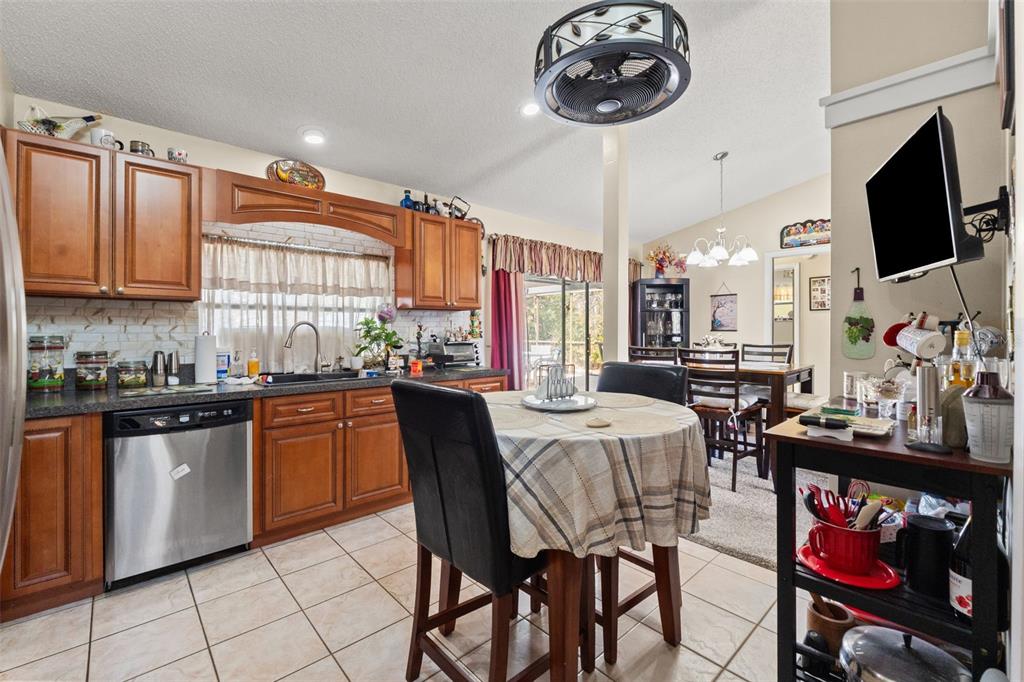 4151 Montano Avenue Spring Hill, FL 34609 - Photo 15 of 34 a kitchen with stainless steel appliances granite countertop a stove a sink dishwasher and cabinets with wooden floor