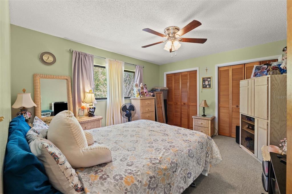 4151 Montano Avenue Spring Hill, FL 34609 - Photo 17 of 34 a spacious bedroom with a bed and a refrigerator