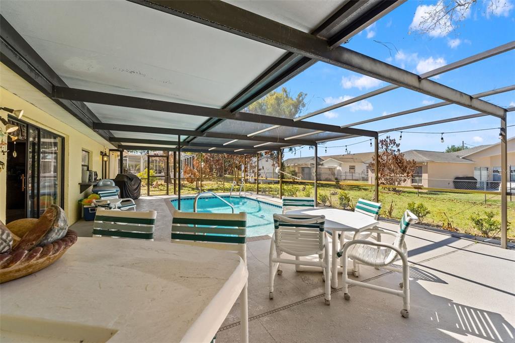4151 Montano Avenue Spring Hill, FL 34609 - Photo 26 of 34 a view of a patio with a table chairs and a patio