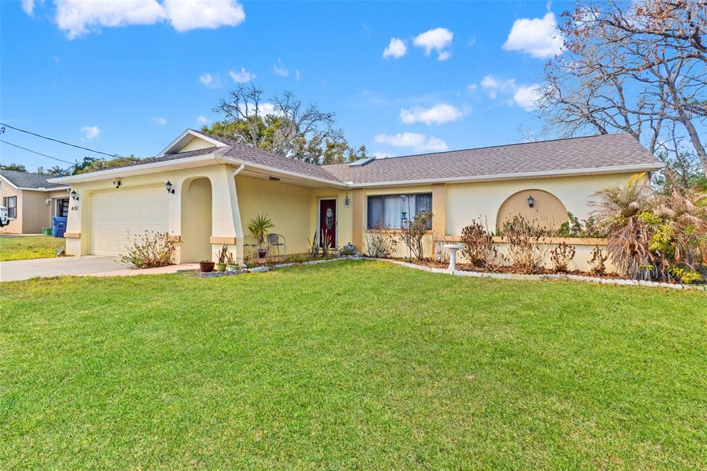 4151 Montano Avenue Spring Hill, FL 34609 - Photo 3 of 34 a front view of a house with garden
