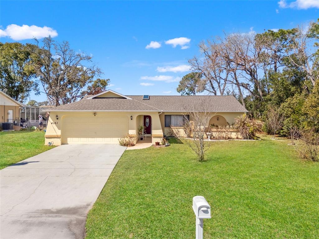 4151 Montano Avenue Spring Hill, FL 34609 - Photo 4 of 34 a front view of a house with garden