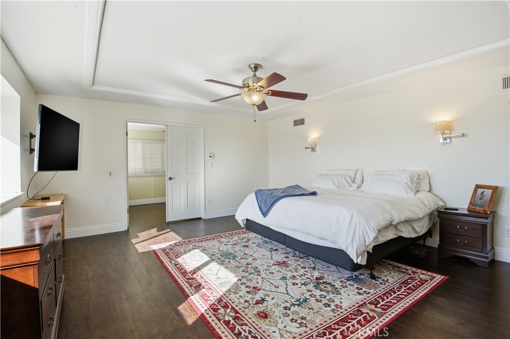 10902 Wilson Avenue Rancho Cucamonga, CA 91737 - Photo 35 of 48 a spacious bedroom with a bed and a flat screen tv
