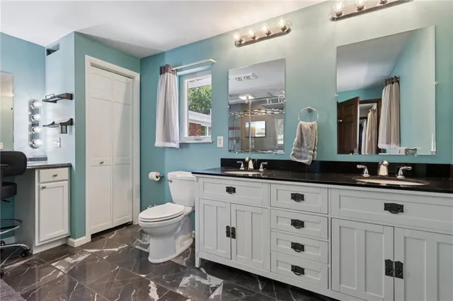 a bathroom with a toilet sink and mirror