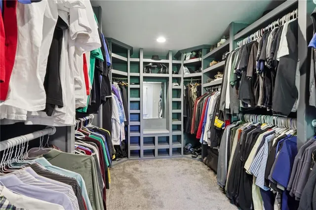 a view of walk in closet with clothes and shoes