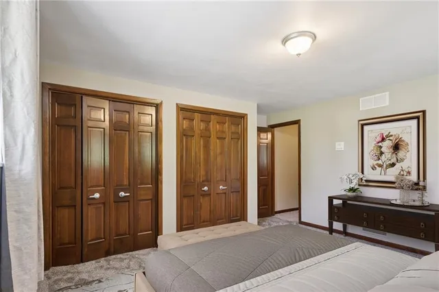 a bedroom with a bed and a painting on the wall