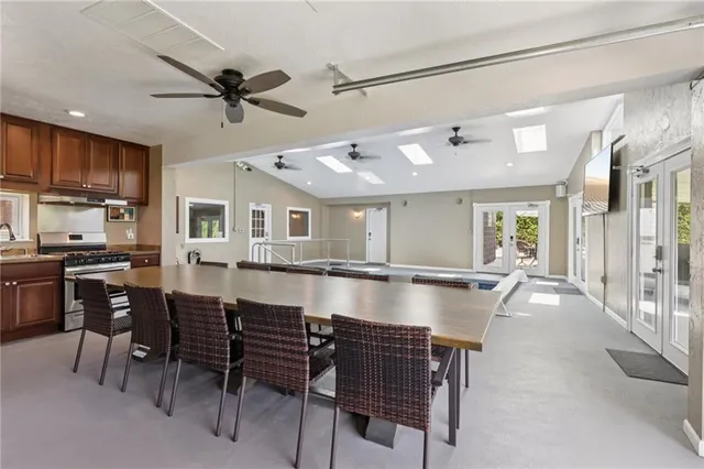 a dining hall with couches a dining table and chairs with wooden floor