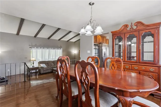 a dining room with furniture a chandelier and wooden floor