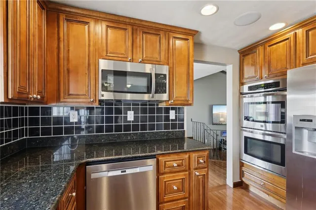a kitchen with stainless steel appliances a stove a microwave and a sink