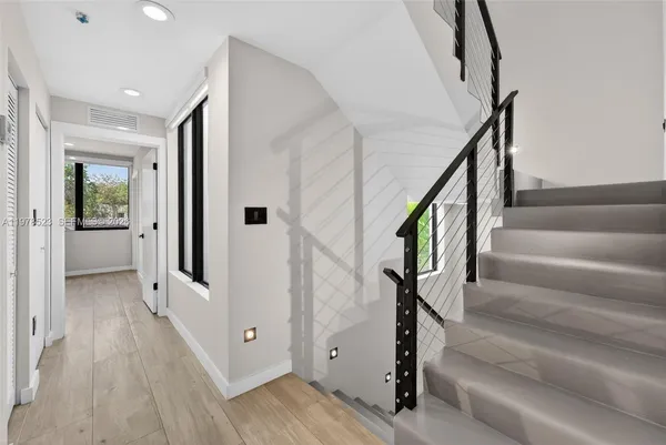 a view of staircase with white walls and wooden floor