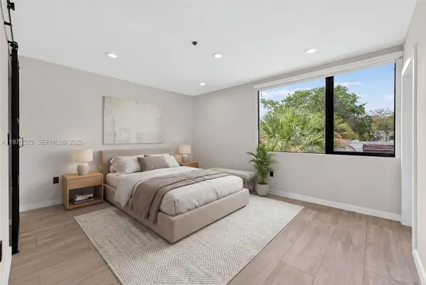 a spacious bedroom with a large bed and a large window