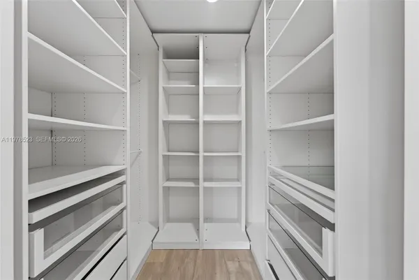 a view of walk in closet with empty racks