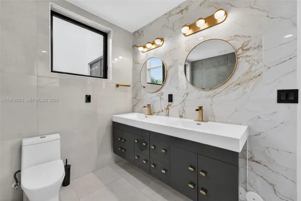 a bathroom with a toilet sink and mirror