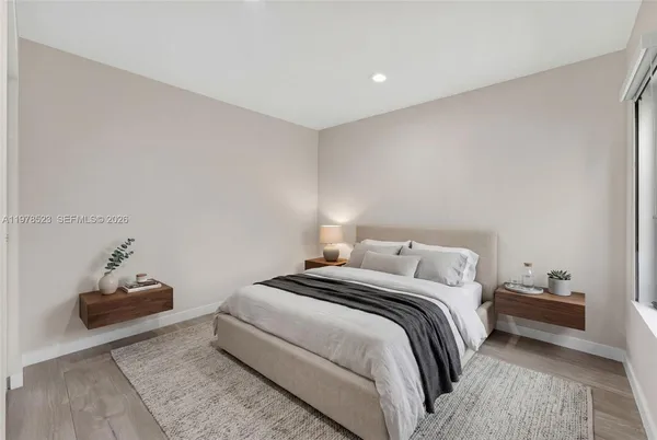 a bedroom with a bed and a lamp on the dresser