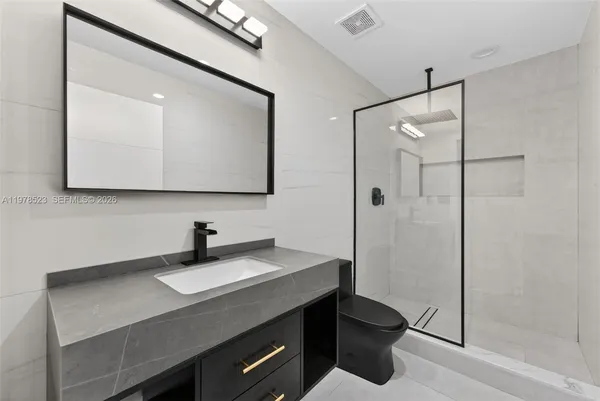 a bathroom with a granite countertop sink a toilet and a mirror