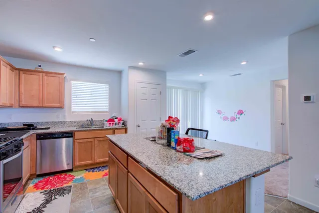 a kitchen with stainless steel appliances granite countertop a sink stove and cabinets