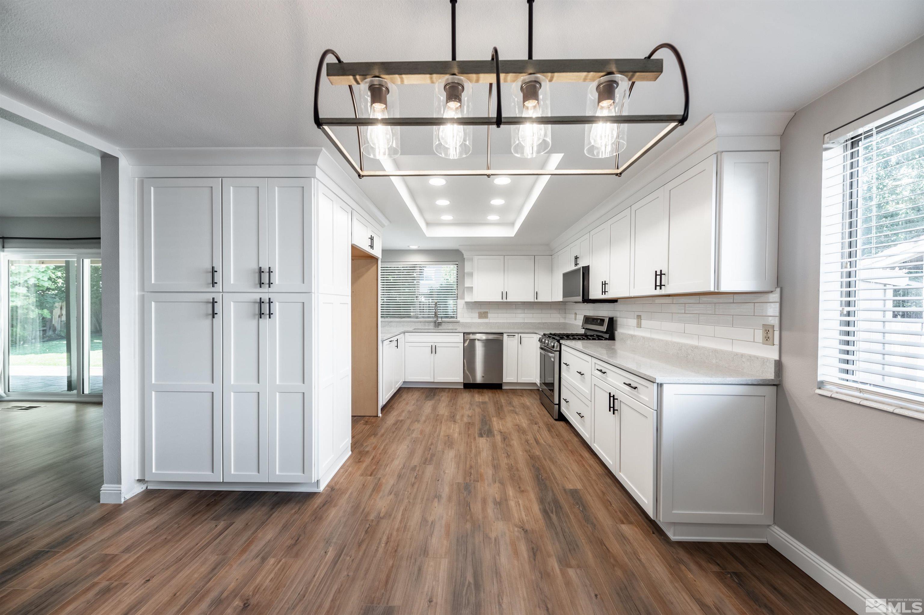 4795 Warren Way Reno, NV 89509 - Photo 11 of 40 a kitchen with stainless steel appliances hardwood floor sink and window