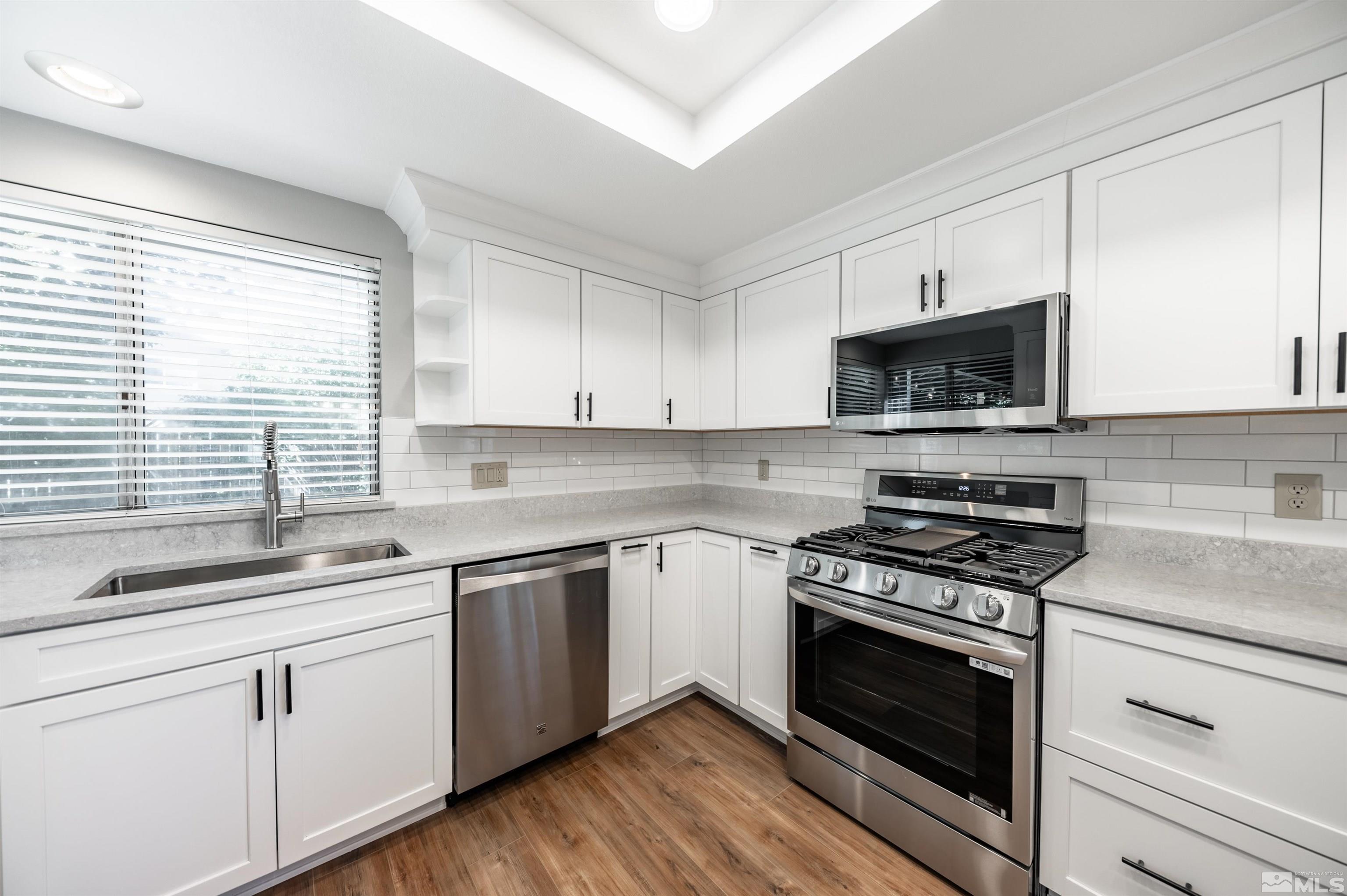 4795 Warren Way Reno, NV 89509 - Photo 13 of 40 a kitchen with cabinets appliances a sink and a window
