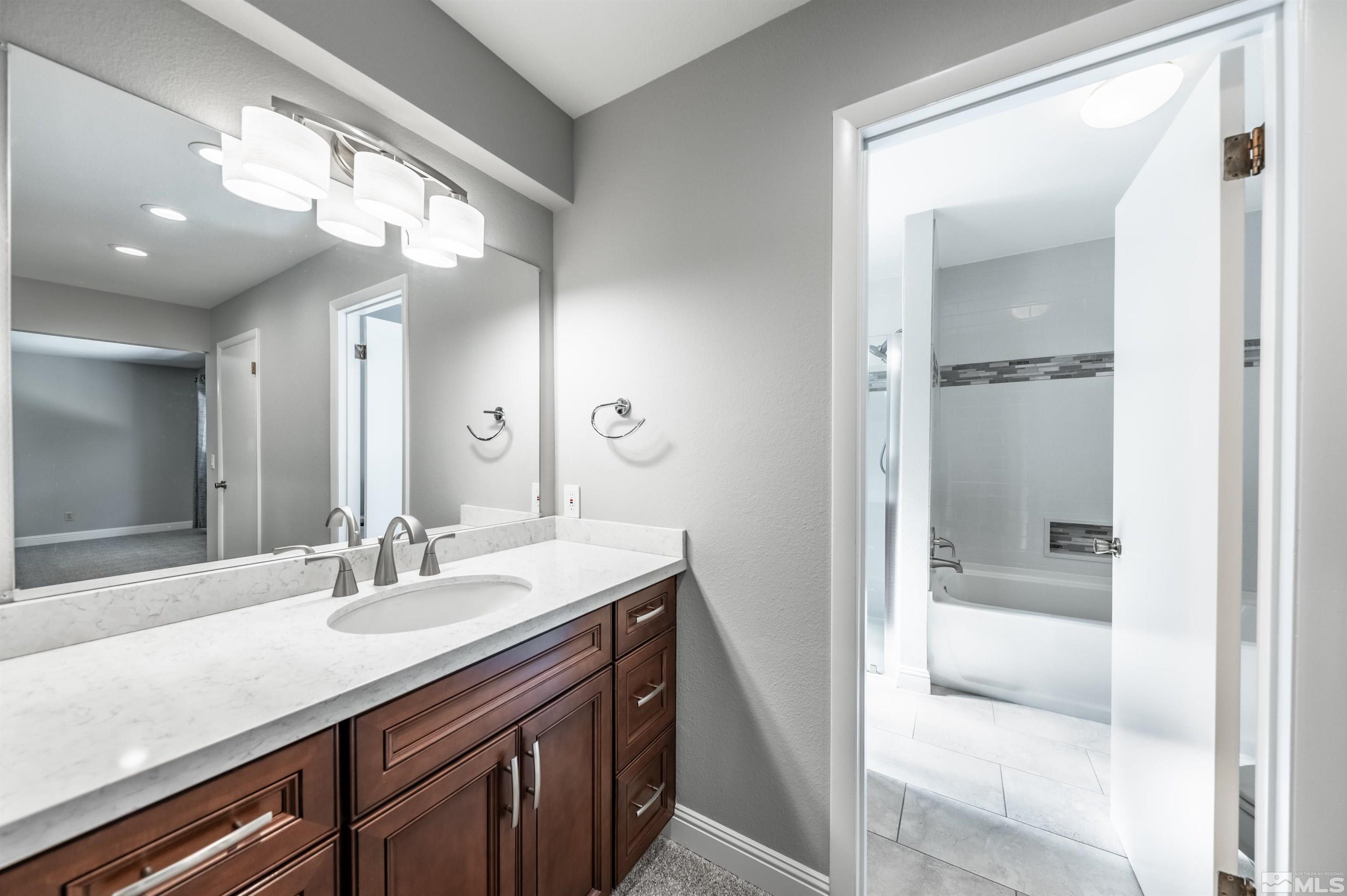 4795 Warren Way Reno, NV 89509 - Photo 18 of 40 a bathroom with a sink a vanity and a mirror