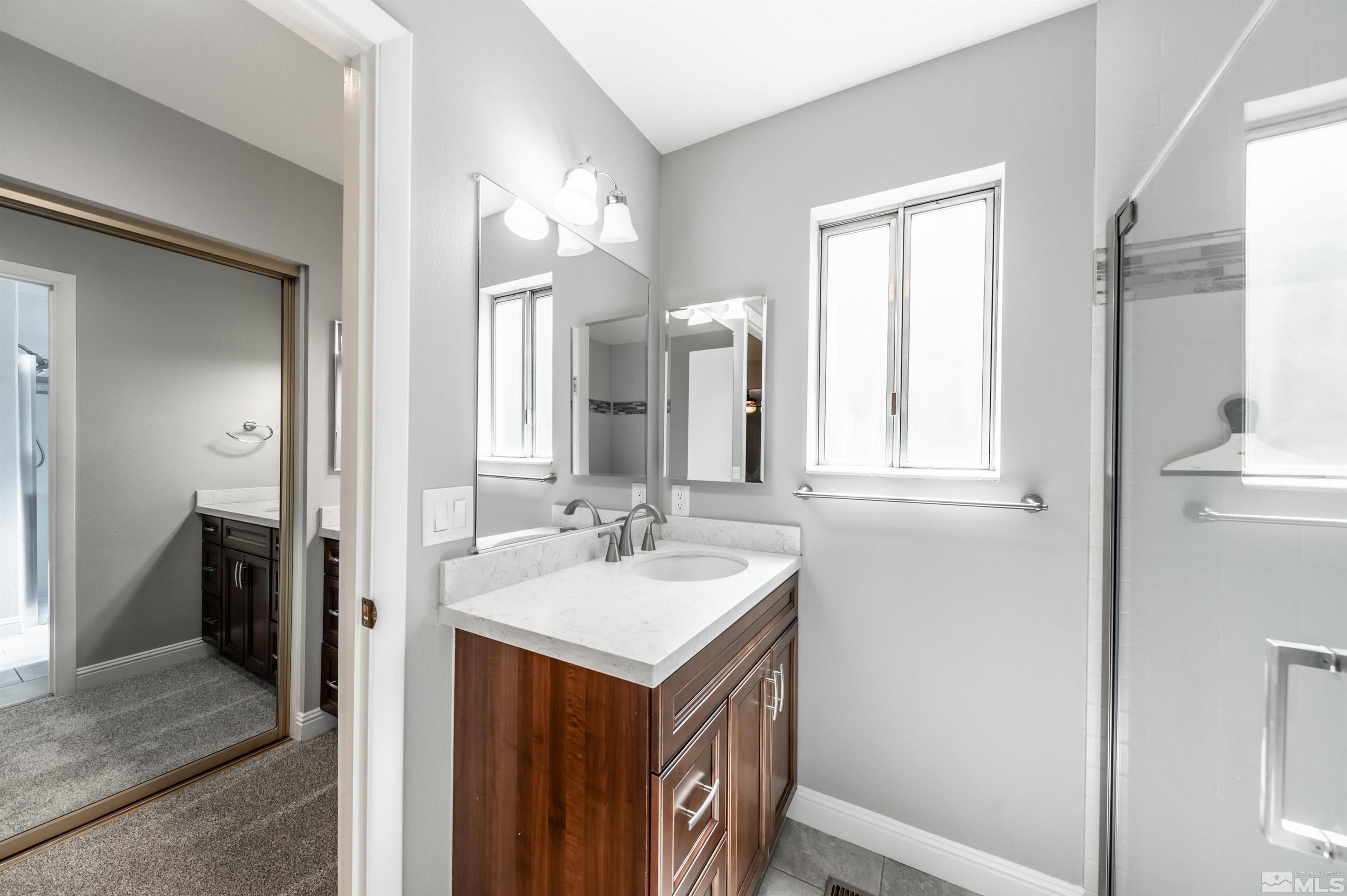 4795 Warren Way Reno, NV 89509 - Photo 19 of 40 a en suite bathroom with a sink vanity and a mirror