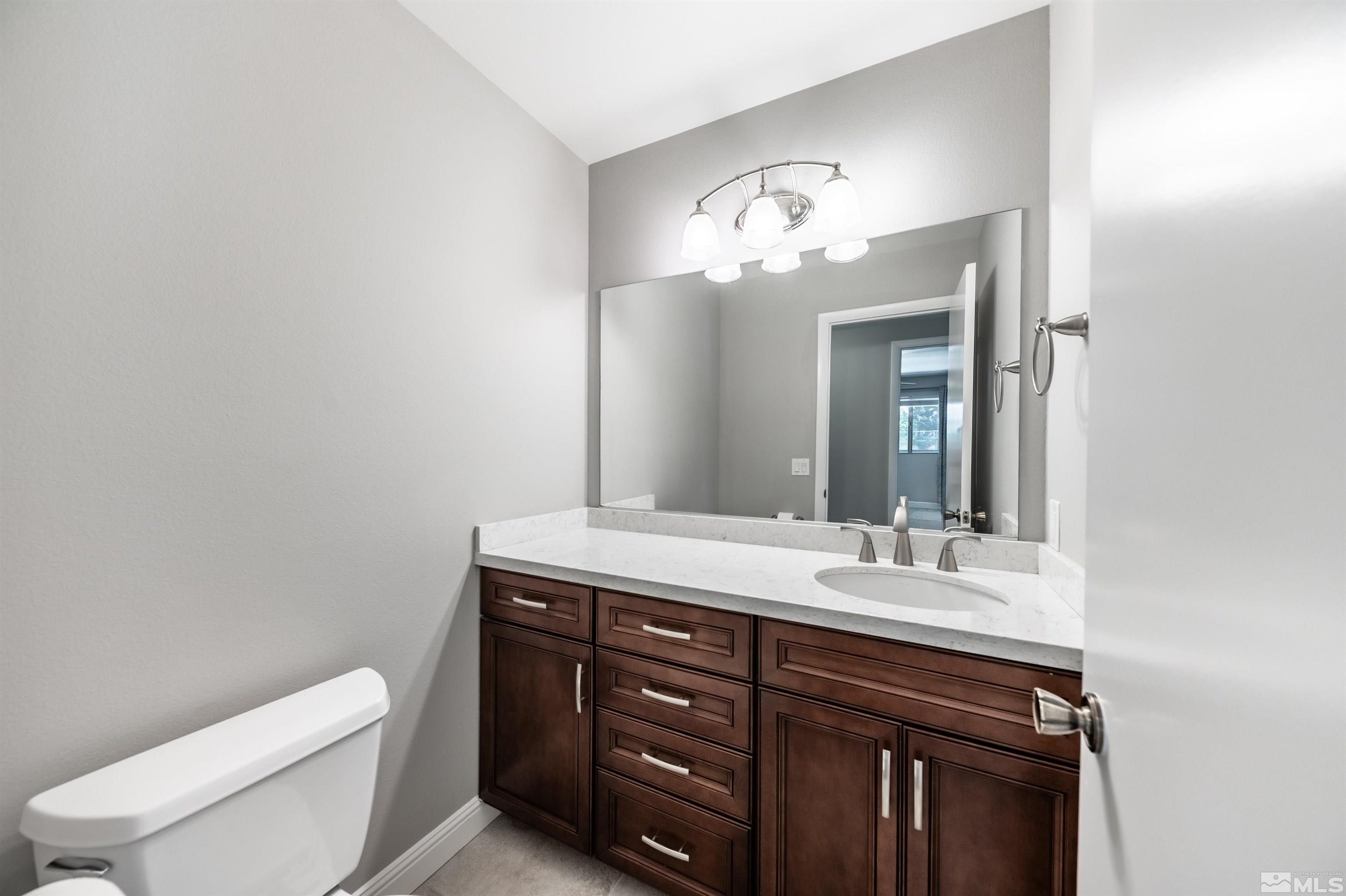 4795 Warren Way Reno, NV 89509 - Photo 23 of 40 a bathroom with a toilet sink and mirror