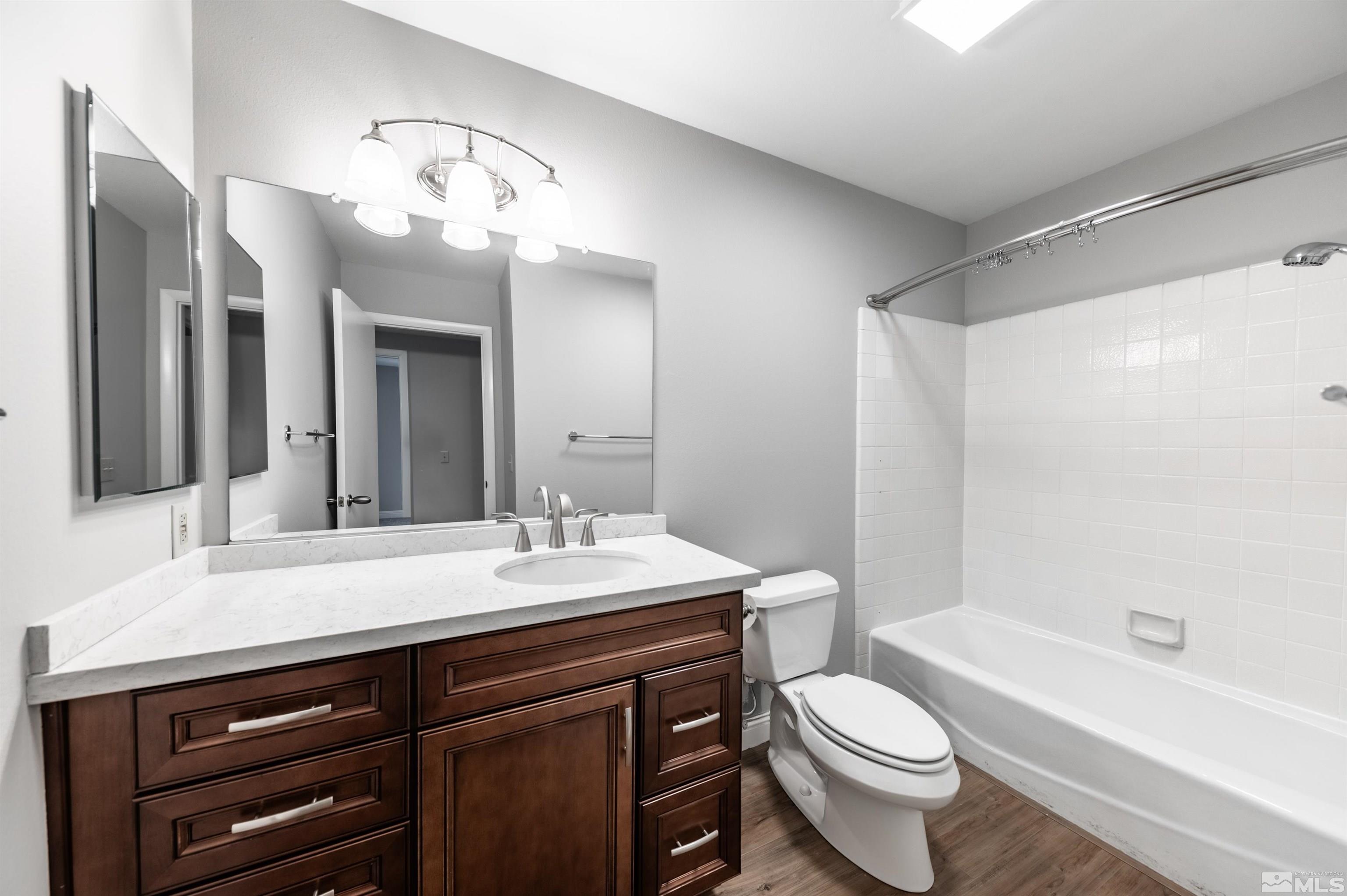 4795 Warren Way Reno, NV 89509 - Photo 26 of 40 a bathroom with a sink a toilet a mirror a bathtub and shower