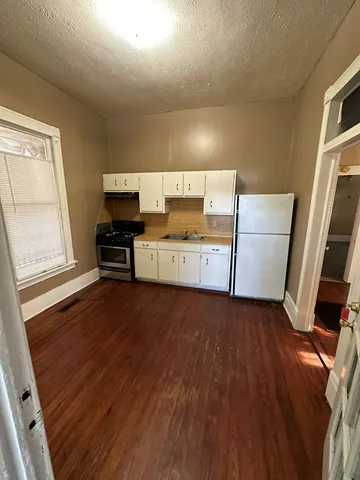a view of a kitchen with furniture and wooden floor