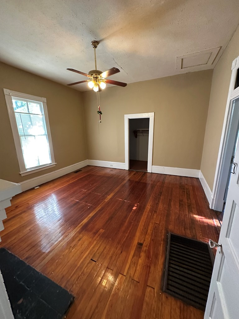 1329 19th Street, Unit B Columbus, GA 31901 - Photo 3 of 5 wooden floor in an empty room with a window