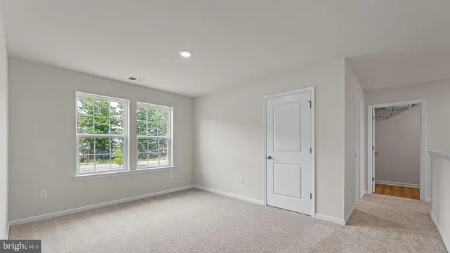 an empty room with windows and closet